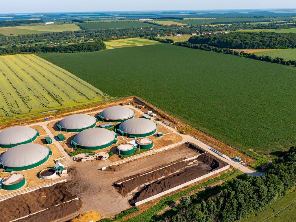 Umgeben von großen Feldern ist eine Biogasanlage zu sehen.