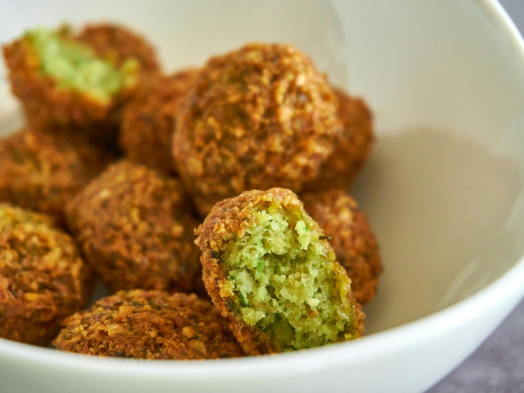 Falafel sind fritierte Bällchen - außen knusprig braun und innen grünlich.