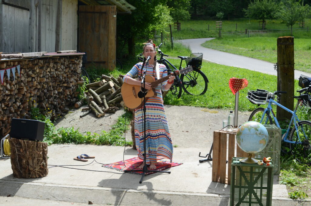 Die Liedermacherin Irene Mazza mit Mikrofon und Gitarre.