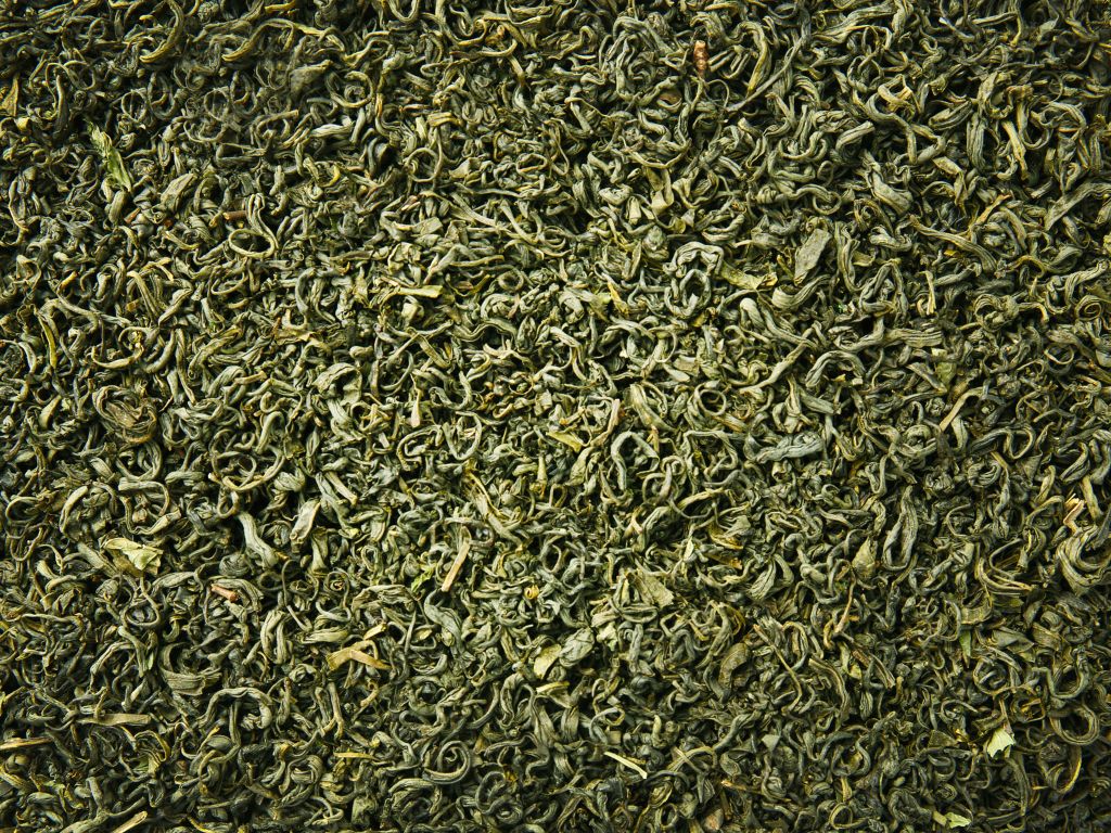 Eine Menge grüner, getrockneter Teeblätter ist fotografiert.