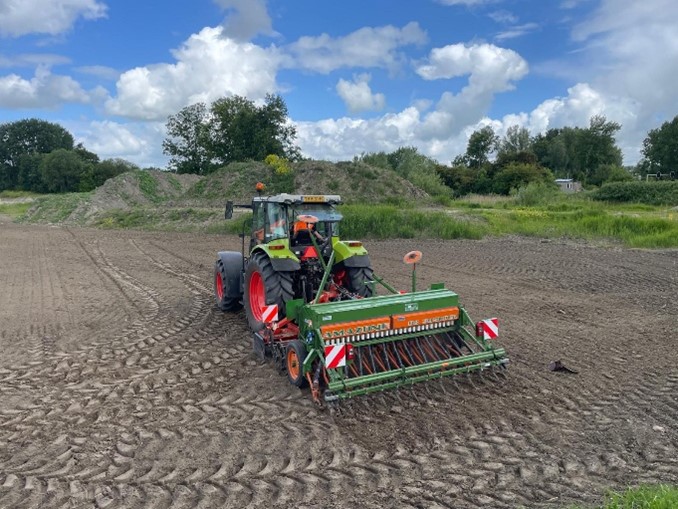 Ein Traktor fährt auf dem zukünftigen Weltacker und pflügt den Boden um.