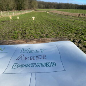 Ein handgezeichneter Zettel liegt vor dem Weltacker, darauf steht "Weltacker Dortmund".