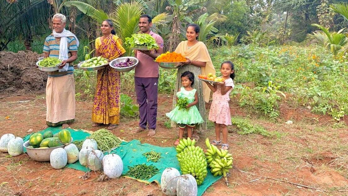 Vier Erwachsene und zwei Kinder halten Schüsseln mit Blumen, Obst und Gemüse