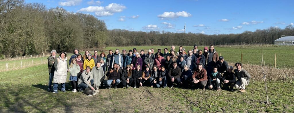 A large group stands in a field for a group photo.