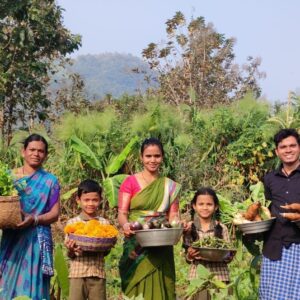 Die Bäuerin Arika Narasamma steht mit ihrer Familie auf ihrem Feld und hält Schalen mit Ernte.