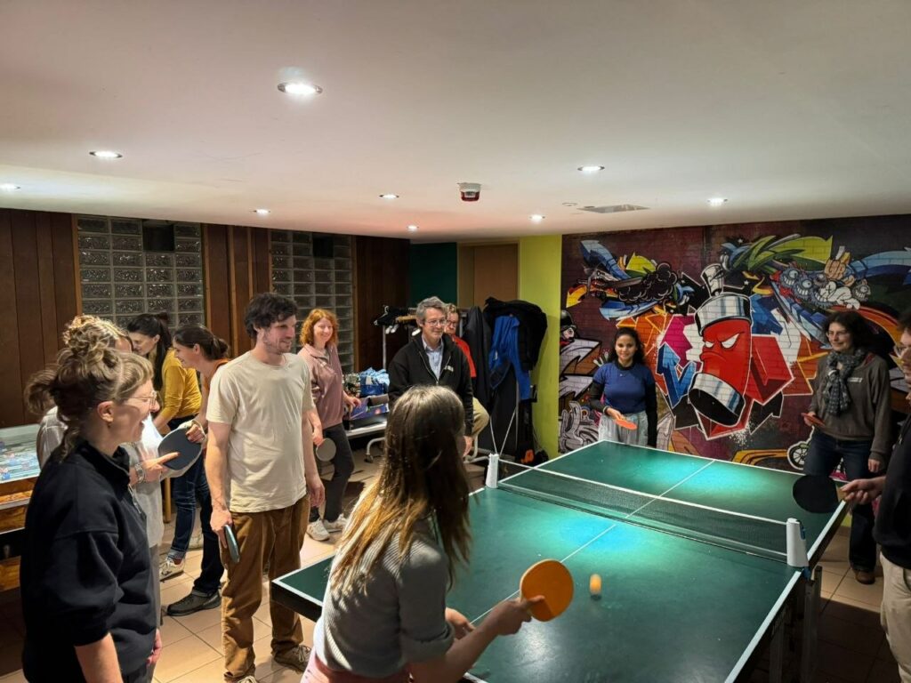 Eine Gruppe spielt Tischtennis und läuft dabei im Kreis um die Platte.